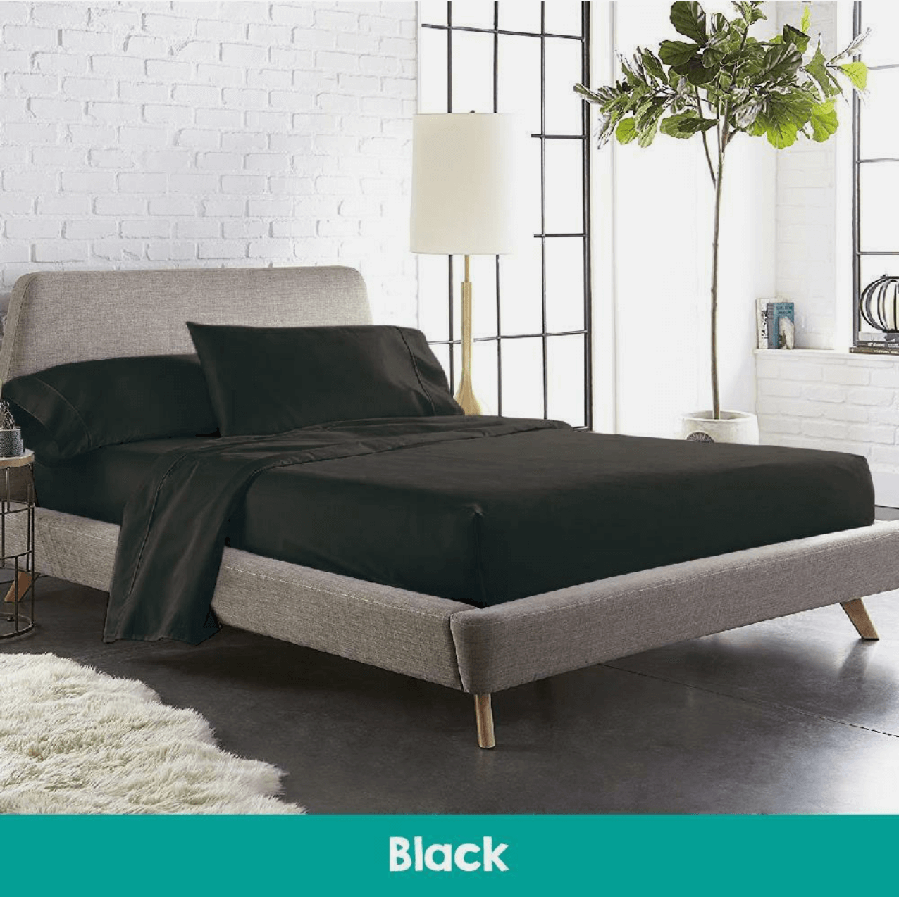 Modern bedroom featuring a bed with black cotton sheets and a matching quilted mattress topper, creating a sleek and sophisticated sleep environment.