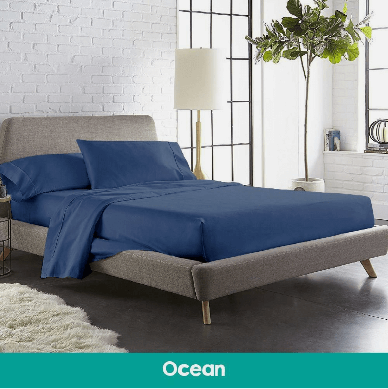 Modern bedroom featuring a bed with navy blue cotton sheets and a matching quilted mattress topper, adding a stylish and cozy touch to the space