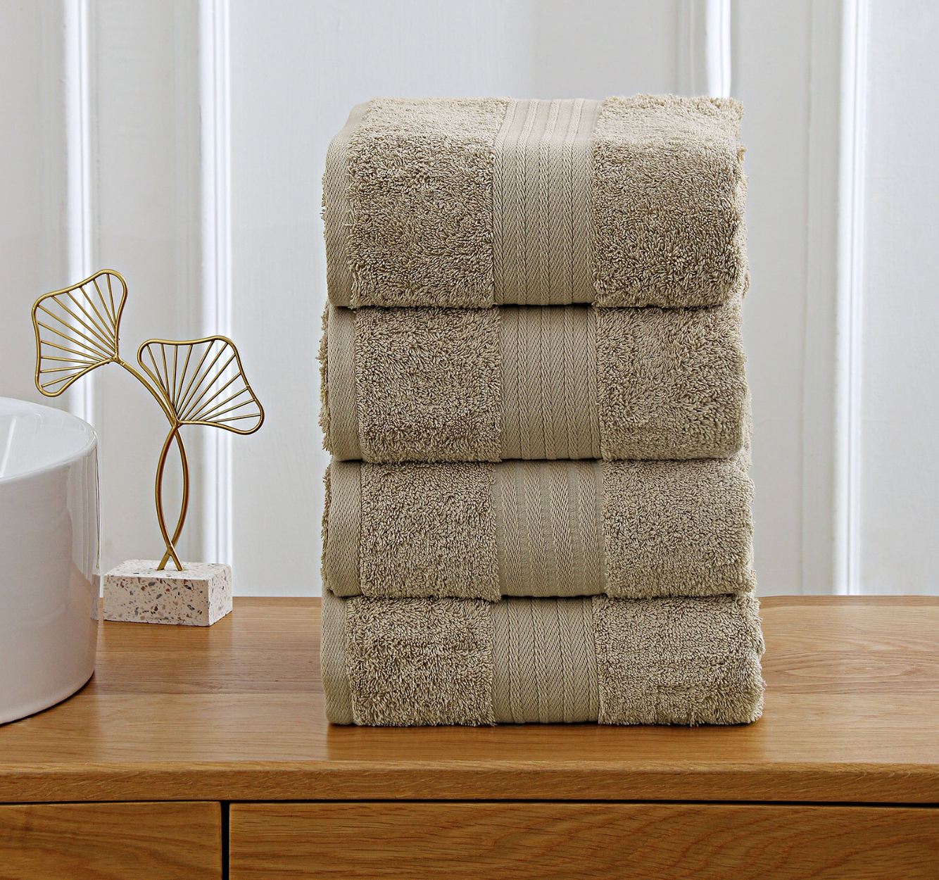 beige towels stacked on wooden shelf