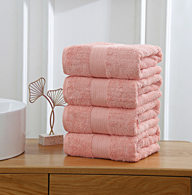 pink towels stacked on wooden shelf
