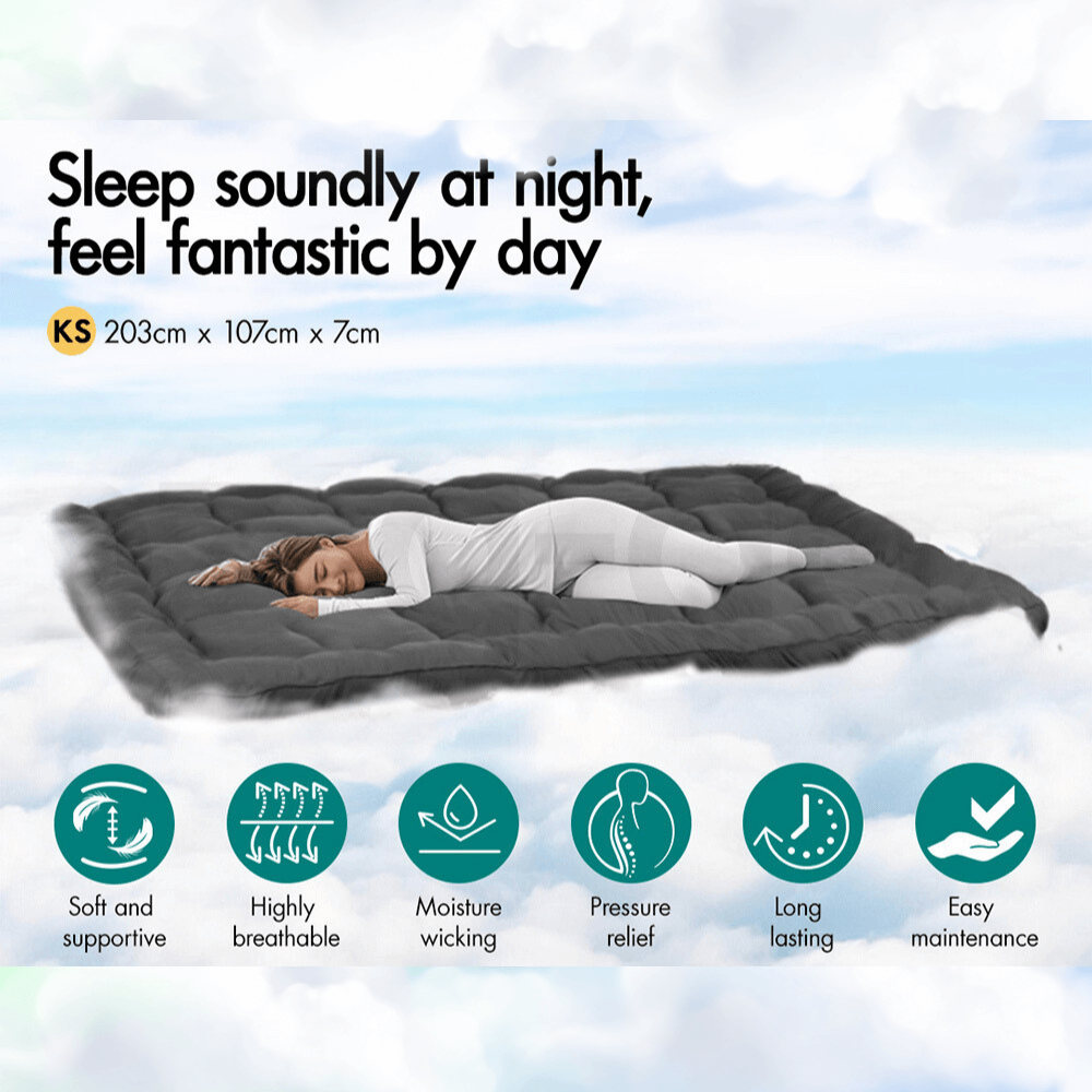 Woman sleeping peacefully on a dark gray quilted mattress topper, with icons highlighting its key benefits such as breathability, softness, pressure relief, and temperature regulation