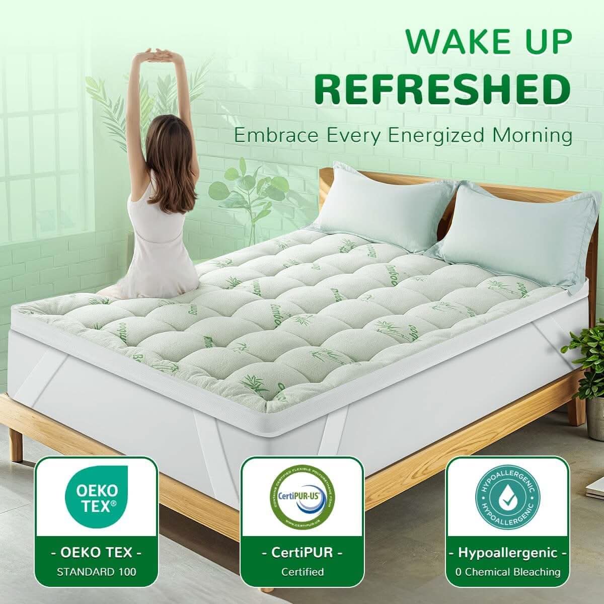 Bedroom with a white quilted mattress topper on a wooden bed frame, featuring text that reads 'Wake Up Refreshed' and icons highlighting comfort, breathability, and support benefits