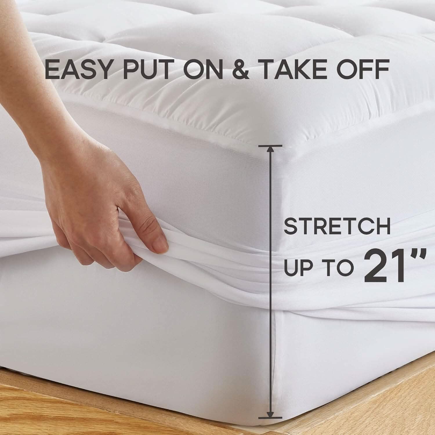 Hand adjusting a deep-pocket mattress topper with elastic edges, designed for easy fitting and secure placement on mattresses up to 53 cm thick