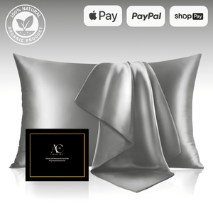 Elegant silver silk pillowcase set with a matching silk cloth, accompanied by a black gift box, highlighting its luxurious and smooth texture.