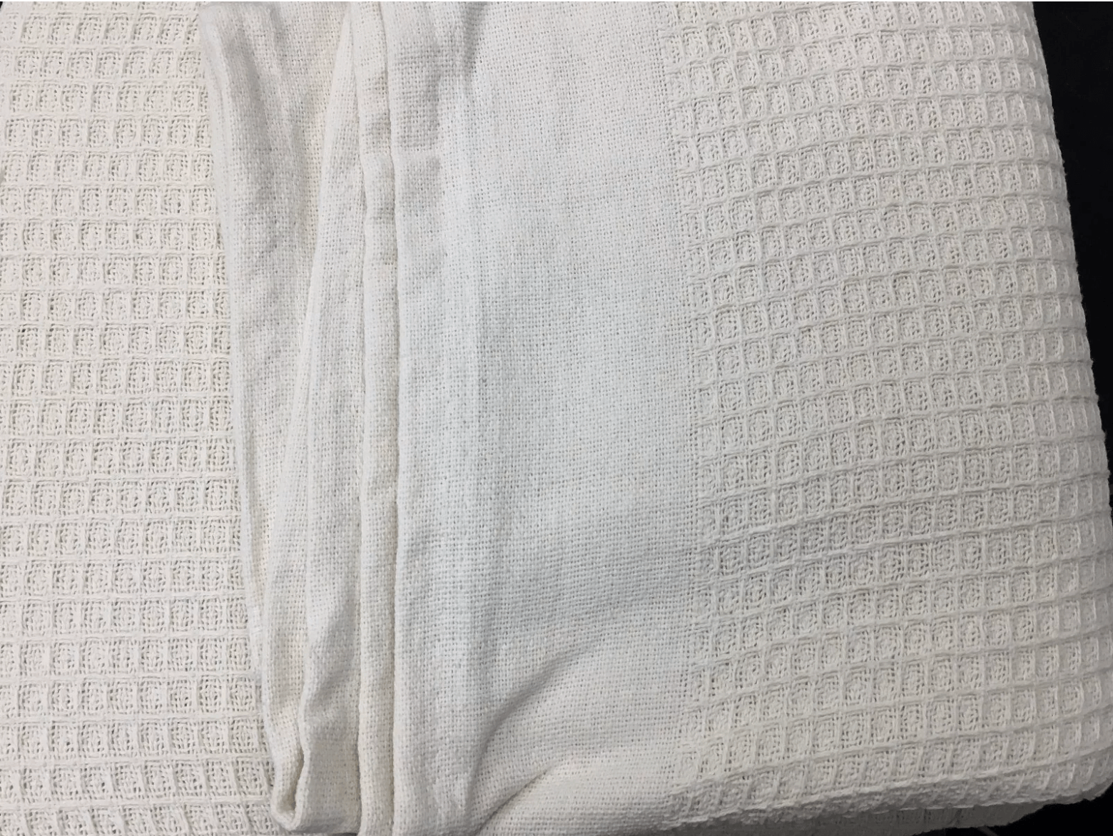 White cotton waffle blanket neatly folded - Soft and breathable waffle blankets for ultimate comfort and warmth.