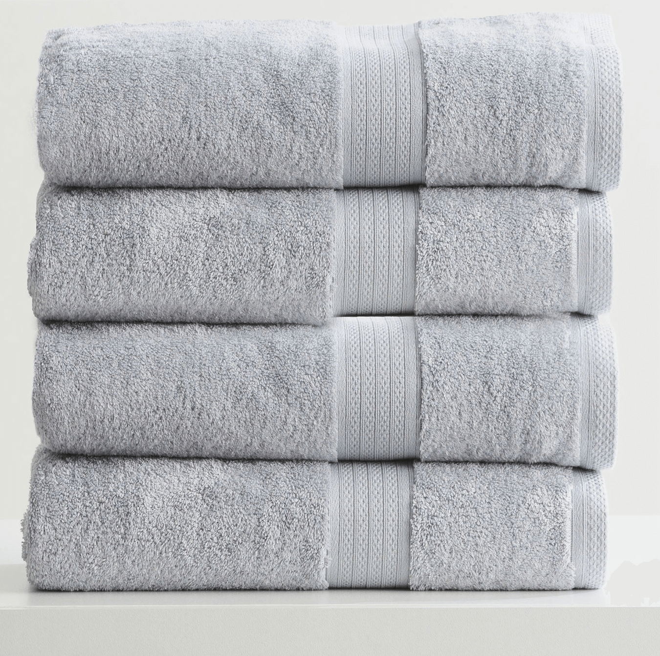 Stack of four folded gray towels with textured stripes, neatly arranged on a white surface.