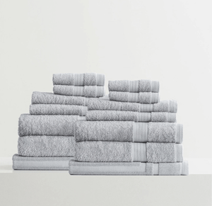 Set of neatly stacked gray bath towels in various sizes on a white surface.